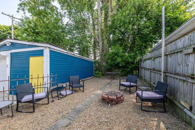 Back patio with a fire pit and chairs behind the house