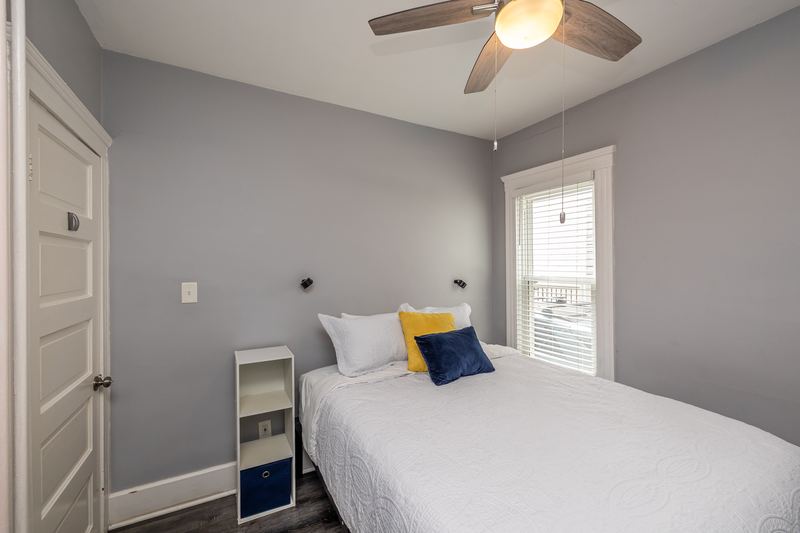 Bedroom with white bedding and navy and yellow pillows