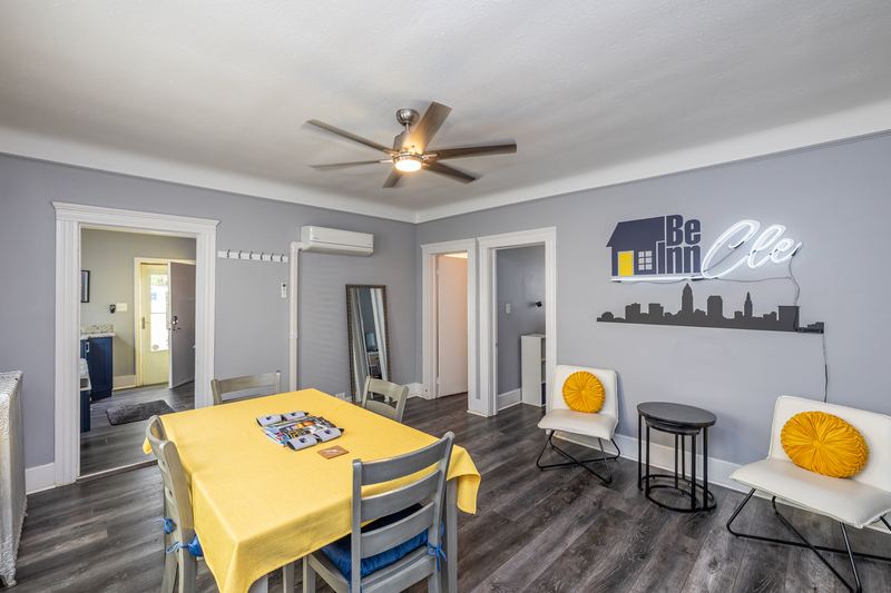 Dining table with a yellow cloth below a Cleveland skyline wall piece