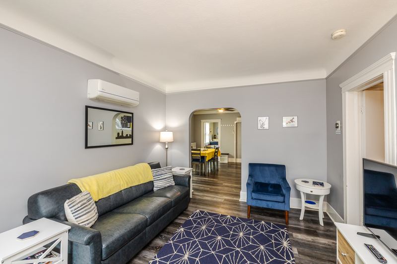Living room with a navy patterned rug, sofa and armchair